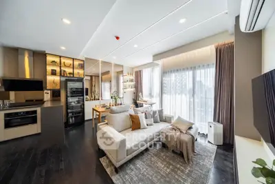 Modern open-layout living room with stylish kitchen and large windows for natural light.