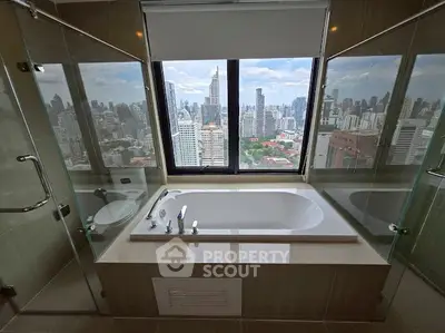 Luxurious bathroom with city skyline view and modern bathtub.