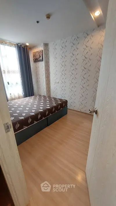 Cozy bedroom with modern decor and natural light in a stylish apartment.