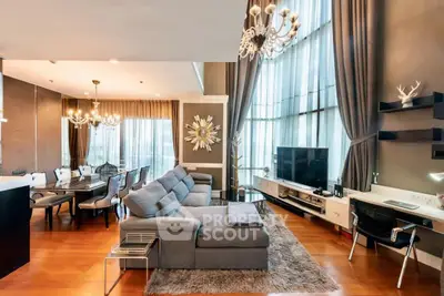 Luxurious living room with high ceilings, elegant chandeliers, and modern decor