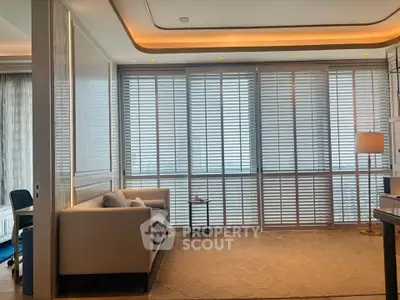Luxurious living room with modern decor and large windows with blinds