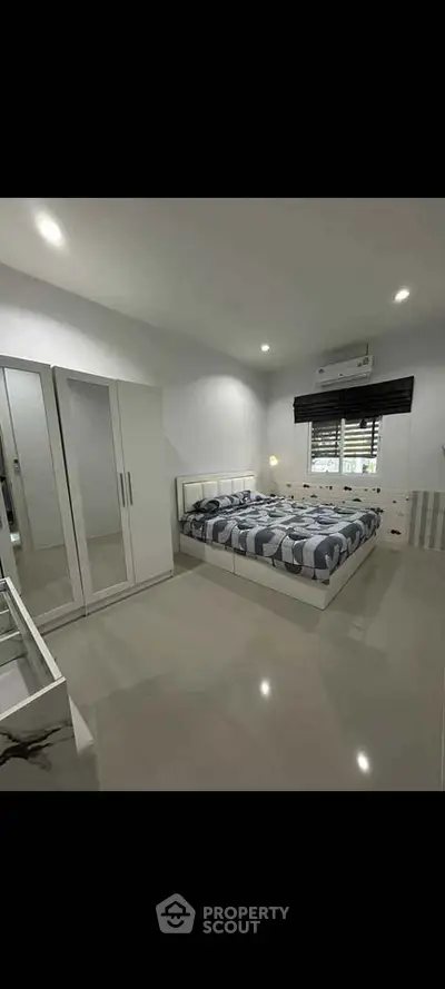Spacious modern bedroom with sleek design and ample natural light