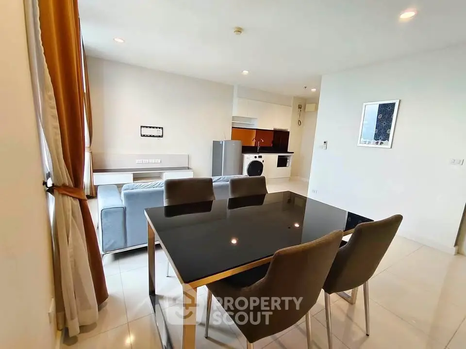 Modern open-plan living and dining area with sleek furniture and appliances.