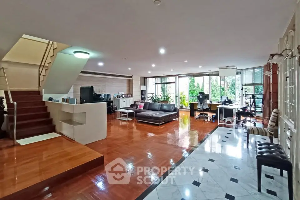 Spacious open-plan living room with modern decor and large windows for natural light.