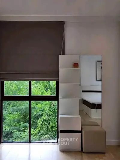 Modern bedroom with large window and stylish storage solution
