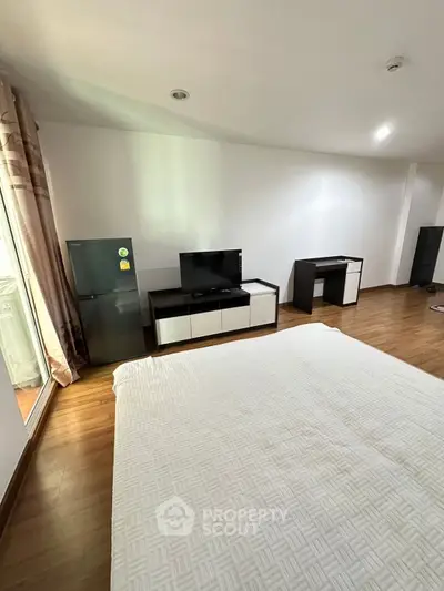 Spacious bedroom with modern furniture and wooden flooring