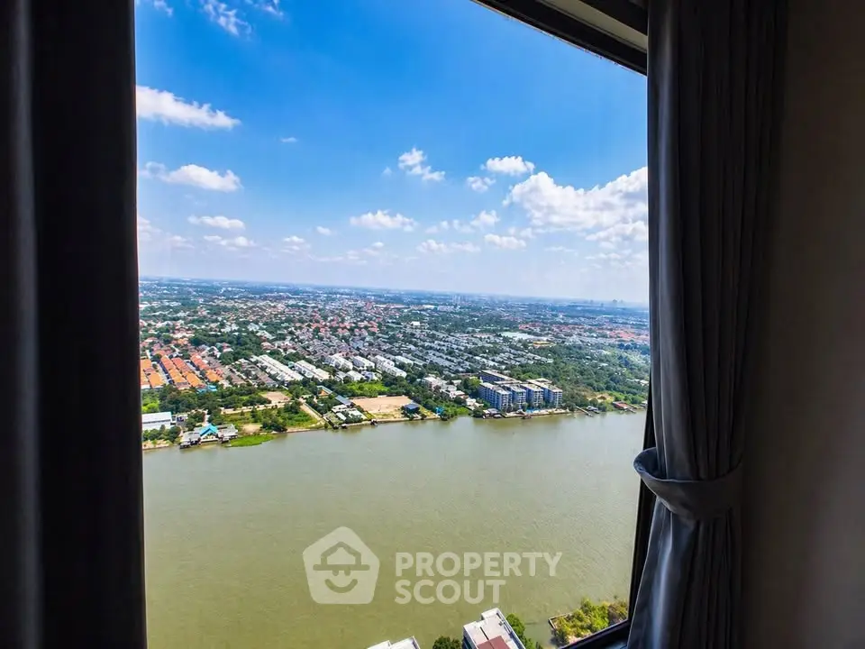 Stunning river view from high-rise apartment window with expansive cityscape.