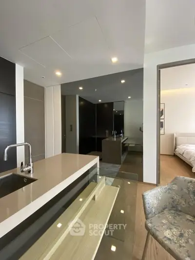 Modern open-layout kitchen with sleek design and adjacent bedroom view