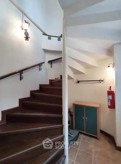 Charming staircase with elegant wooden steps and stylish lighting in a cozy residential setting.