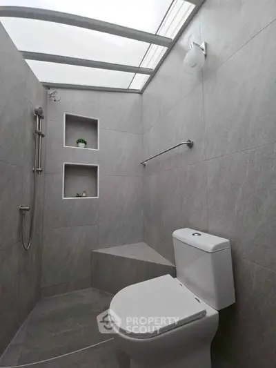 Modern minimalist bathroom with skylight and sleek gray tiles