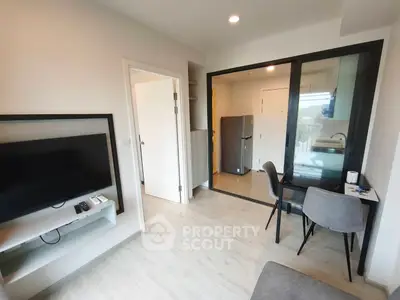 Modern apartment interior with open layout, featuring a cozy living area and compact kitchen.