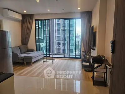 Modern living room with large windows and city view in a stylish apartment.