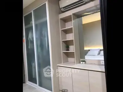 Modern bedroom with built-in wardrobe and air conditioning, featuring sleek design and ambient lighting.