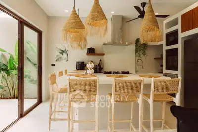 Modern kitchen with open layout, stylish wicker lighting, and sleek appliances, perfect for entertaining.