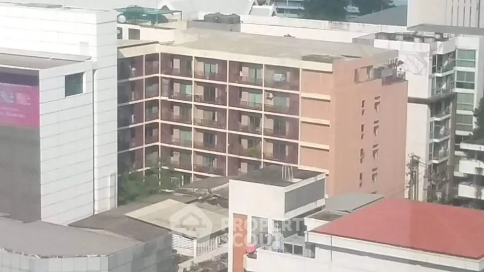 Urban apartment building exterior with multiple balconies and city view.