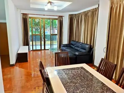 Spacious living room with elegant dining area and large windows for natural light.