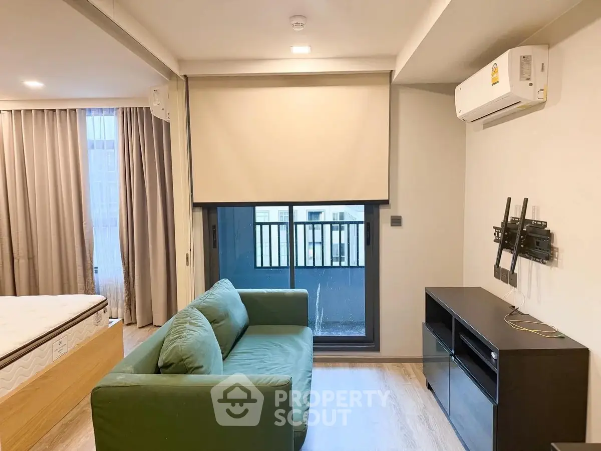 Modern living room with green sofa and balcony view in stylish apartment