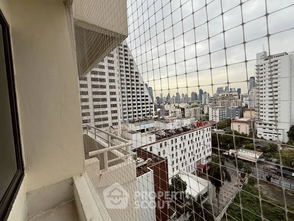 Stunning cityscape view from high-rise balcony with safety netting