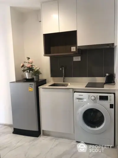 Modern compact kitchen with washing machine and sleek appliances