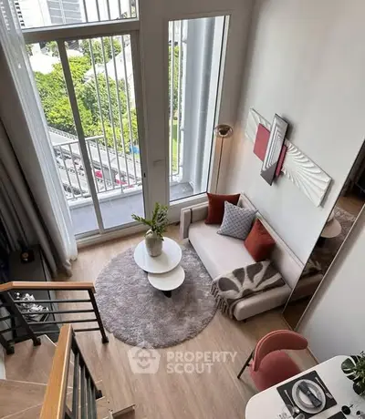 Modern loft apartment with high ceilings and large windows offering a stunning city view.