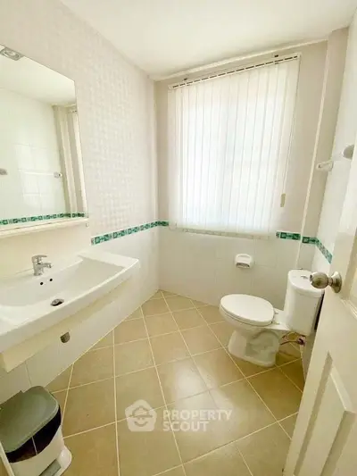 Bright and clean bathroom with modern fixtures and tiled flooring.