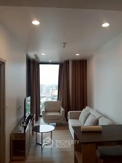 Modern living room with city view, cozy seating, and natural light.