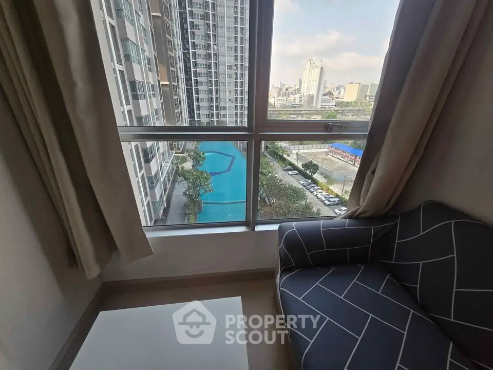 Modern apartment with stunning city view and pool from living room window.