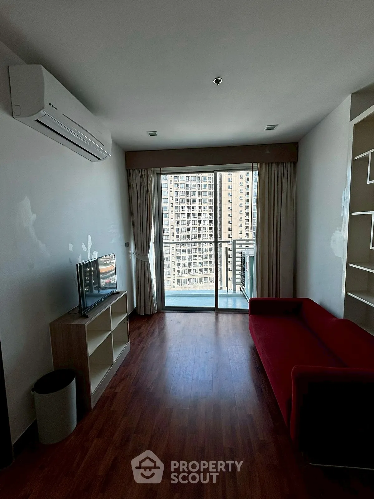 Modern living room with red sofa and city view balcony