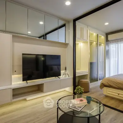 Modern living room with sleek design and open layout, featuring a large TV and stylish furniture.
