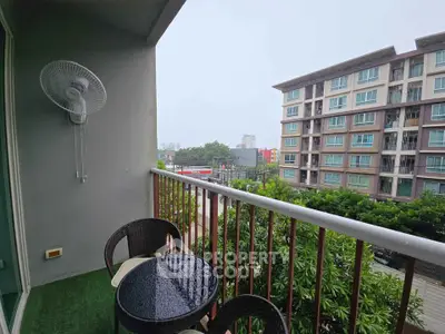 Charming balcony with seating and city view in modern apartment complex.