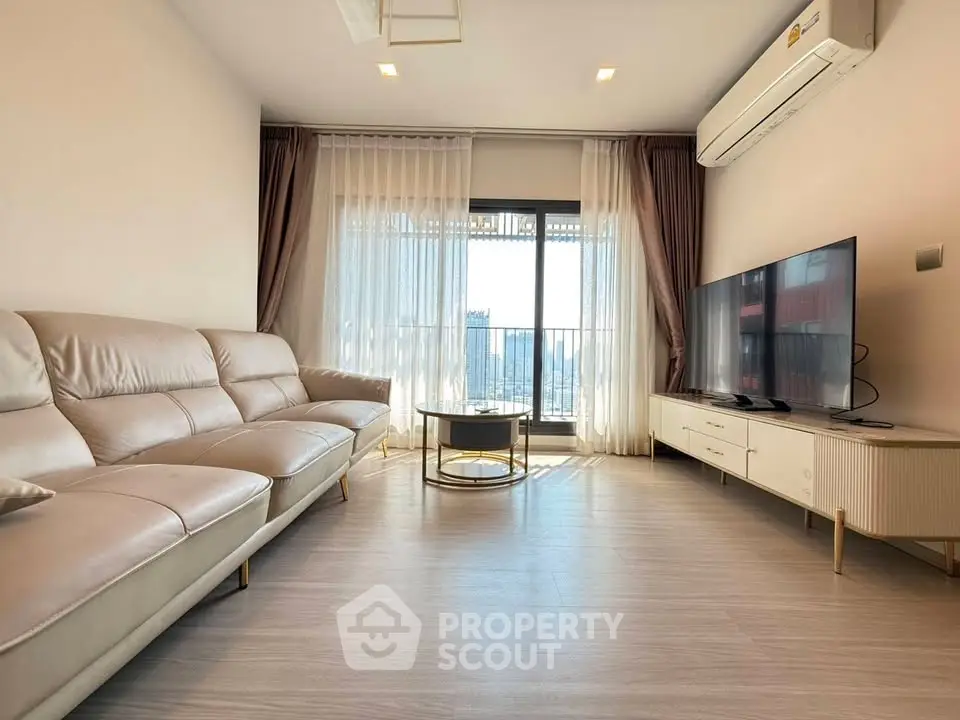 Modern living room with sleek furniture and large window offering city view.