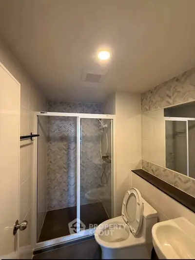 Modern bathroom with glass shower enclosure and sleek fixtures