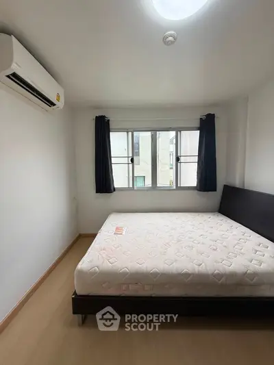 Bright bedroom with large window and modern air conditioning unit