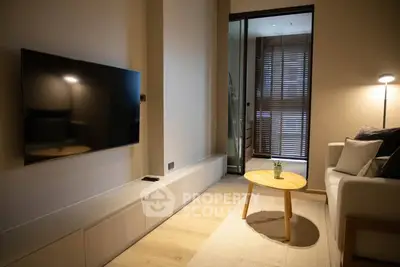 Modern living room with sleek TV, cozy sofa, and stylish decor in a contemporary apartment.