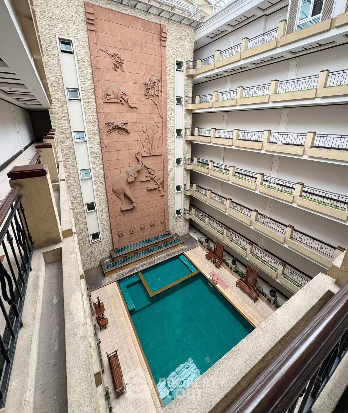 Luxurious indoor pool area with artistic wall design in modern apartment complex