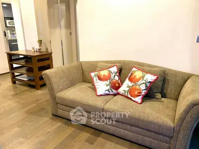 Cozy living room with stylish sofa and decorative pillows, perfect for relaxation.