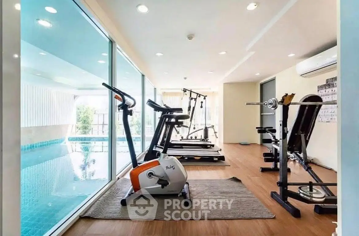 Modern gym with pool view in luxury real estate property