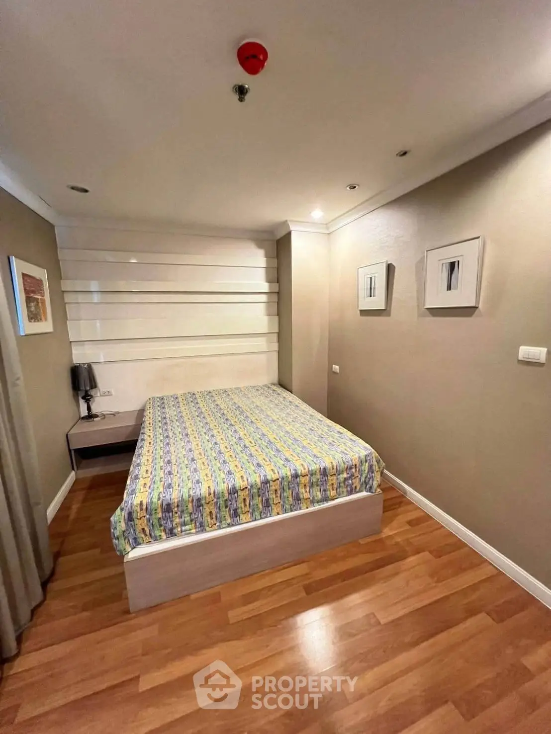 Cozy bedroom with modern decor and wooden flooring in a stylish apartment.