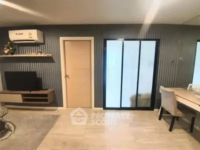Modern living room with sleek design, featuring a TV, air conditioning, and stylish furniture.