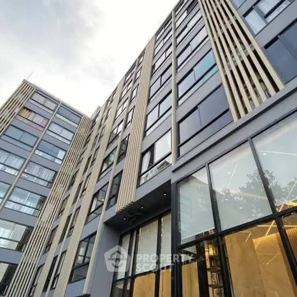 Modern high-rise building with sleek glass facade and contemporary design.