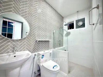 Modern bathroom with stylish herringbone tile and sleek fixtures