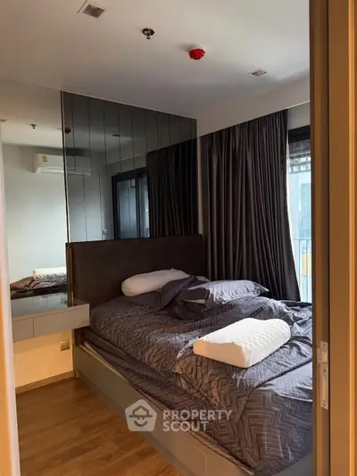 Cozy bedroom with modern decor and mirrored wall in urban apartment