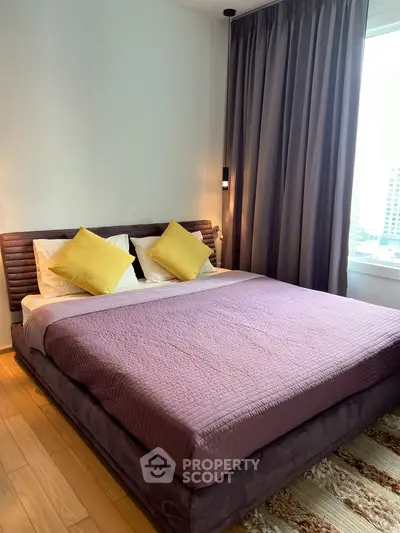 Cozy bedroom with plush bedding and city view, perfect for relaxation and comfort.