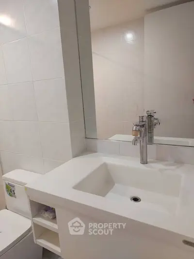 Modern bathroom with sleek white sink and large mirror
