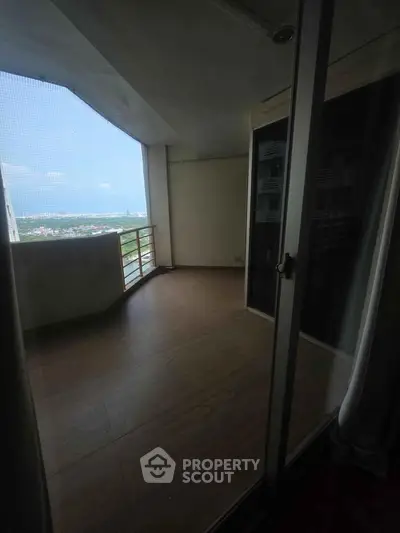 Spacious balcony with stunning city view in modern high-rise apartment.