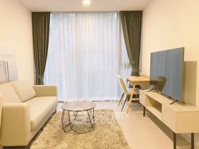 Modern living room with cozy sofa, stylish coffee table, and large TV, perfect for relaxation.