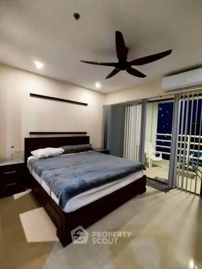 Spacious bedroom with balcony access and modern ceiling fan