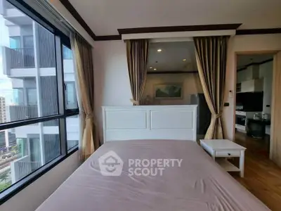 Spacious bedroom with large windows offering city views in modern apartment