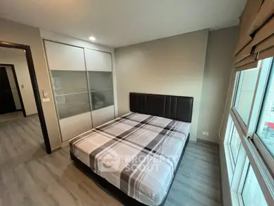 Modern bedroom with large windows and stylish decor in a contemporary apartment.