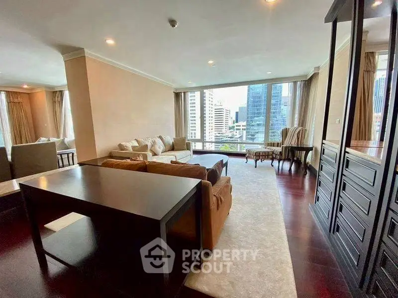 Luxurious living room with city view, elegant furniture, and large windows in high-rise apartment.